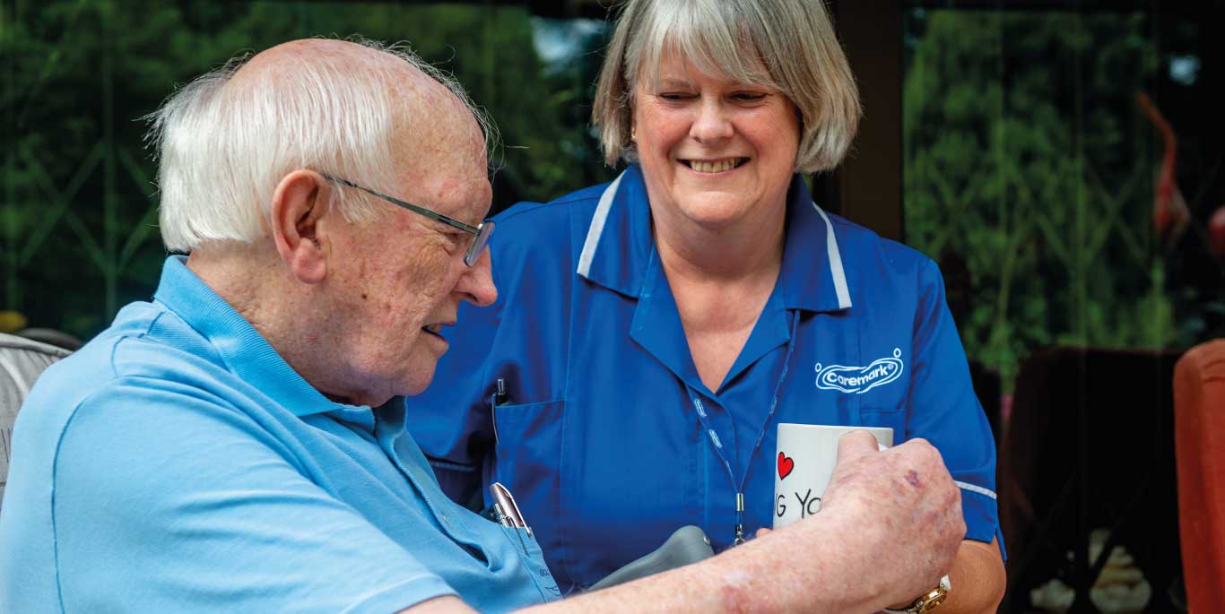 Care staff interacting with a resident over a coffee