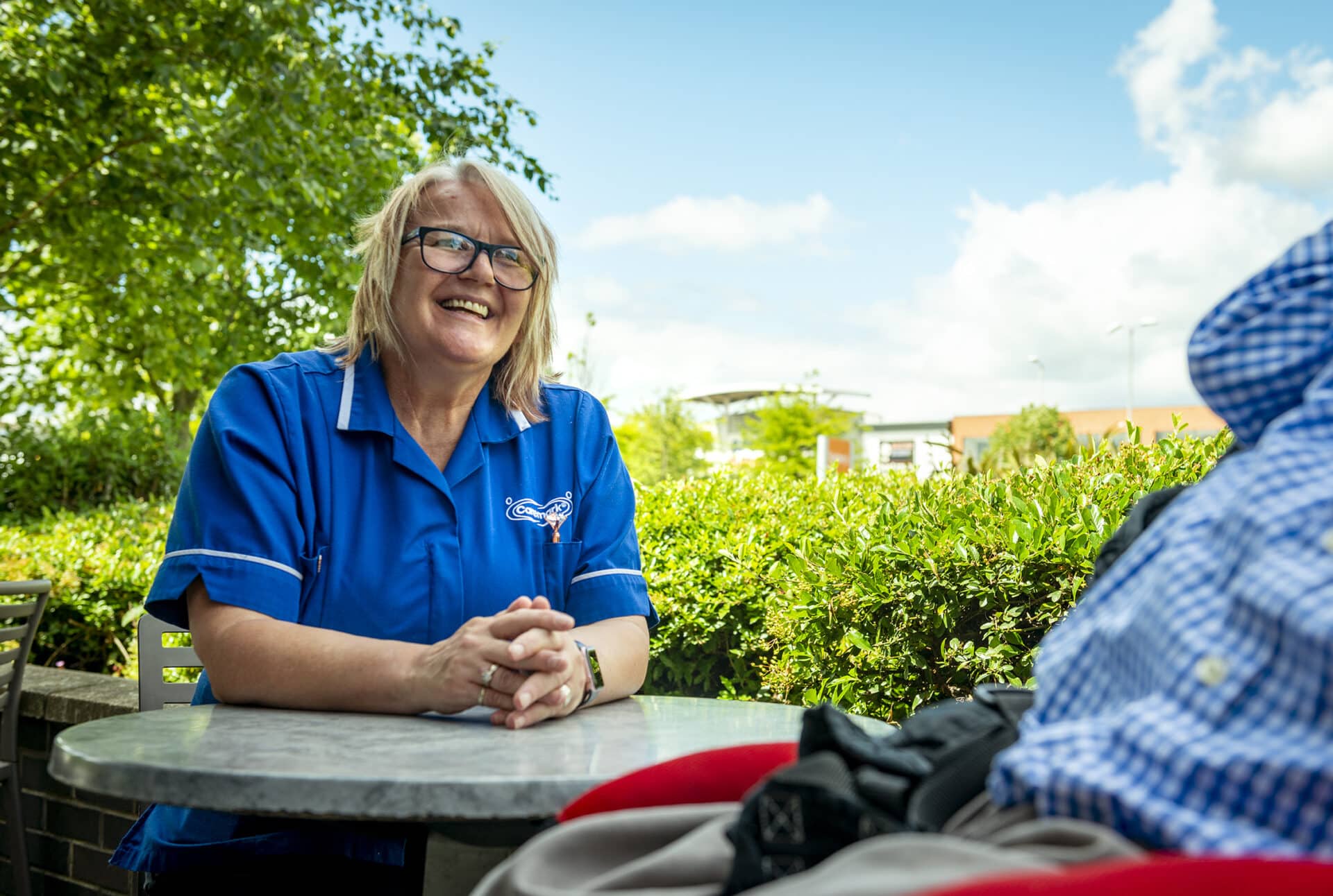 Staff member smiling outdoors with a resident