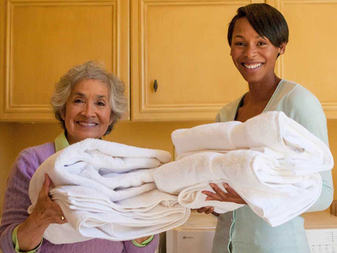 Resident and staff member smiling with towels
