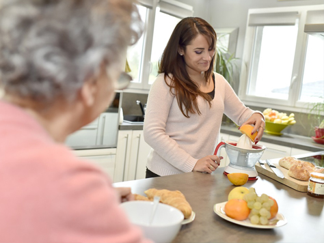 Caregiver assisting senior with food preparation.