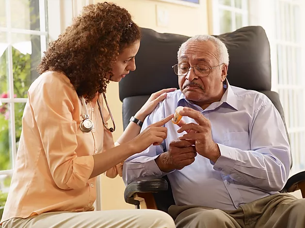 Nurse assisting an elderly patient with medication.