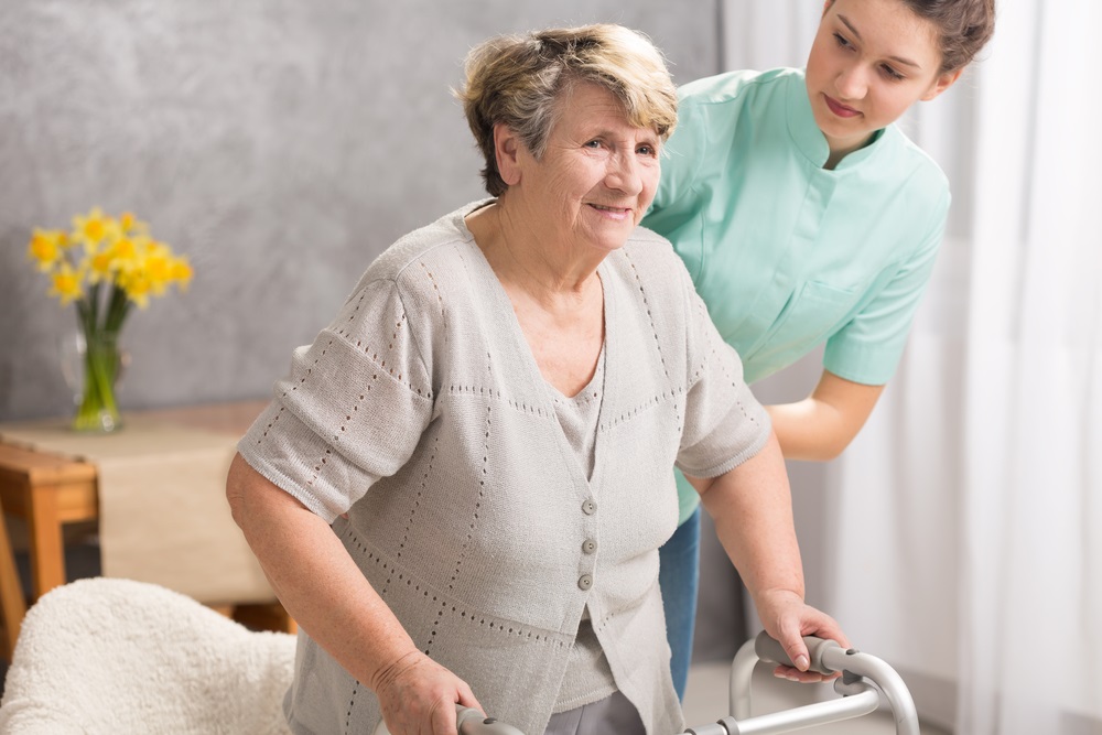 Staff assisting a senior resident in a supportive setting.