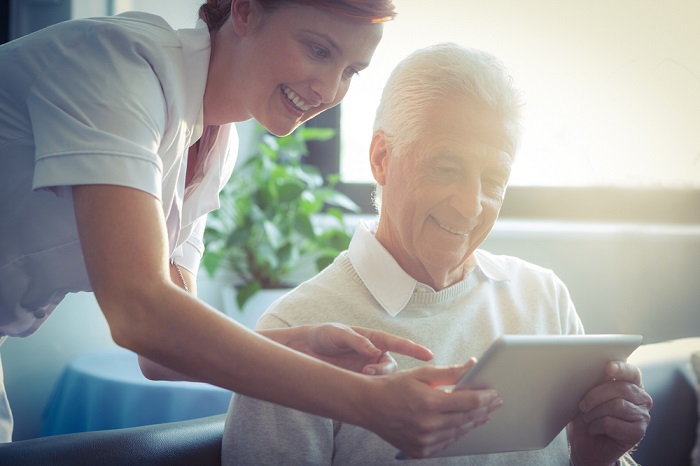 Nurse assisting a senior with a tablet