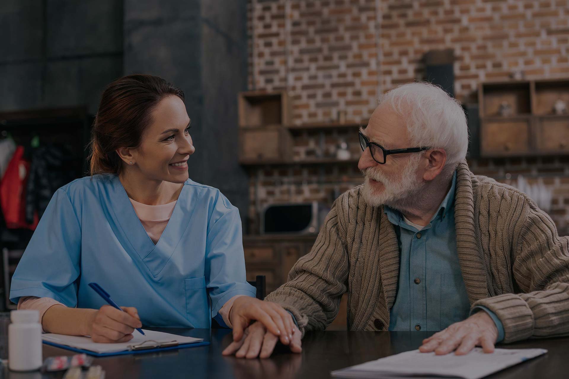 Caregiver interacting with an elderly man in a caring environment.