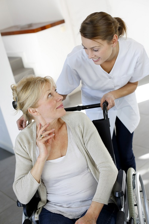 A caregiver assisting a woman in a wheelchair