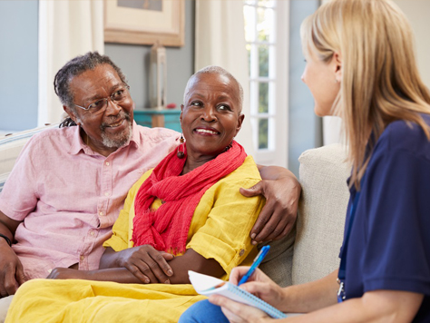 Caregiver interacting with two elderly residents.