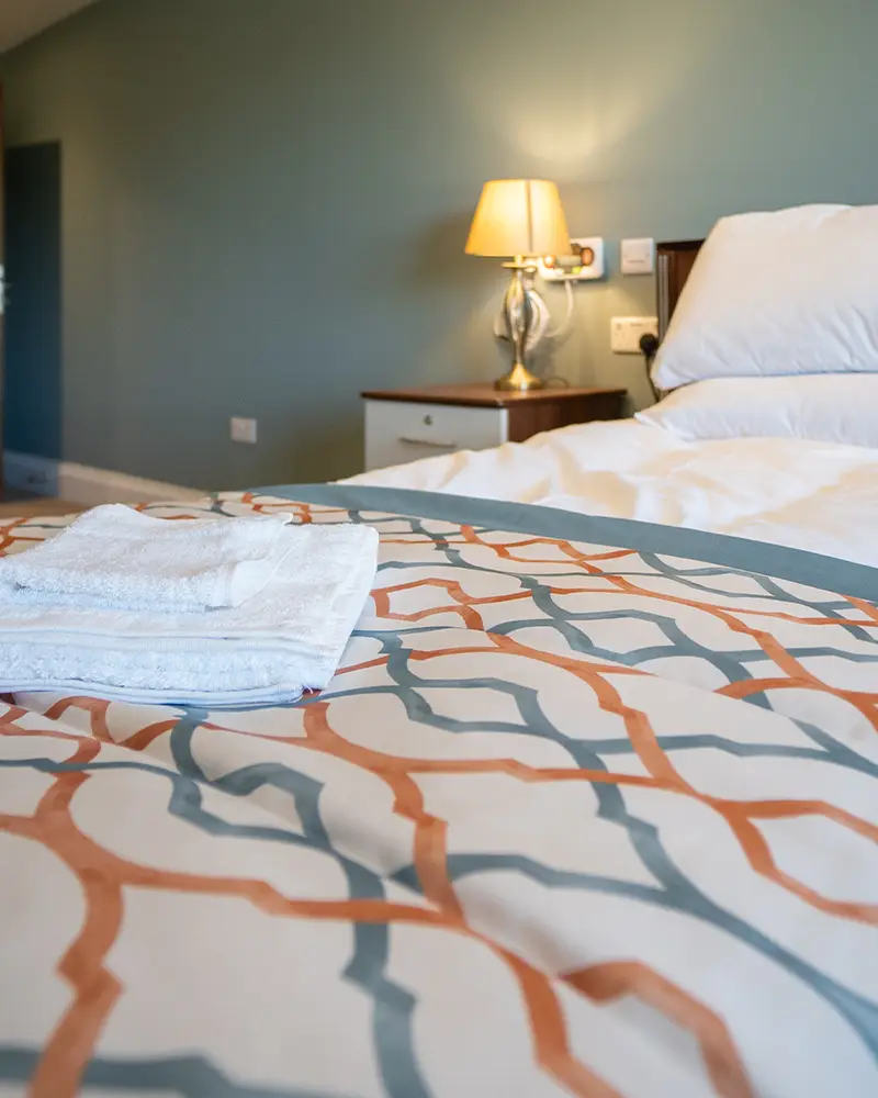 Cozy bedroom setup with towels neatly folded.