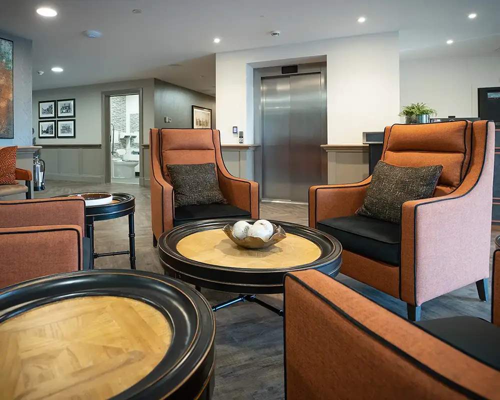 Cozy common area with orange chairs and tables