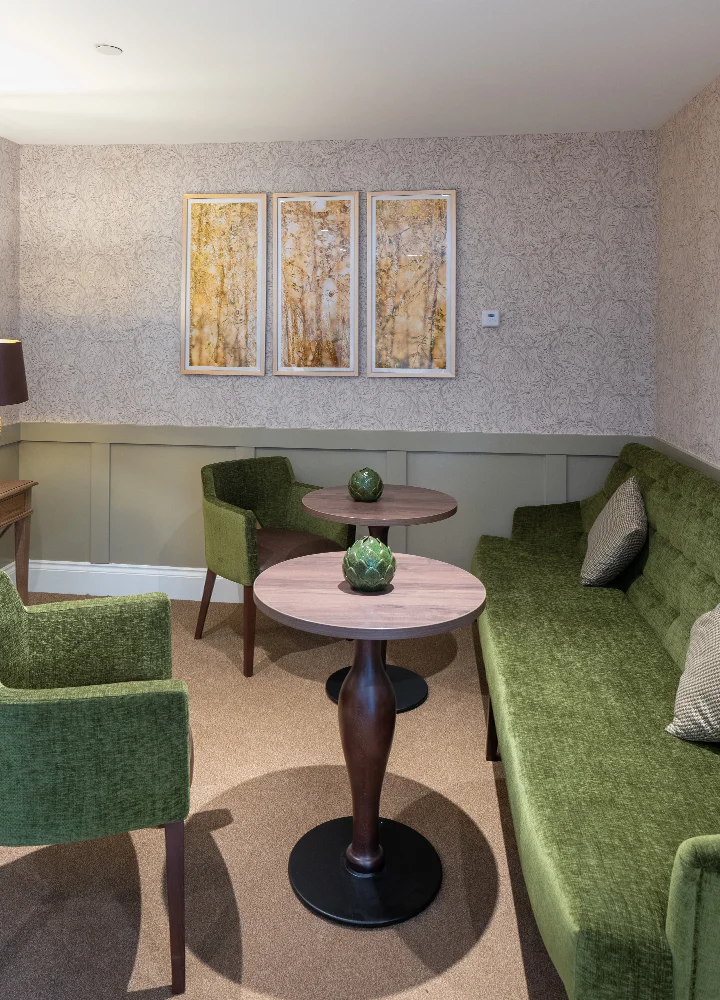 Cozy common area with green seating and artwork.