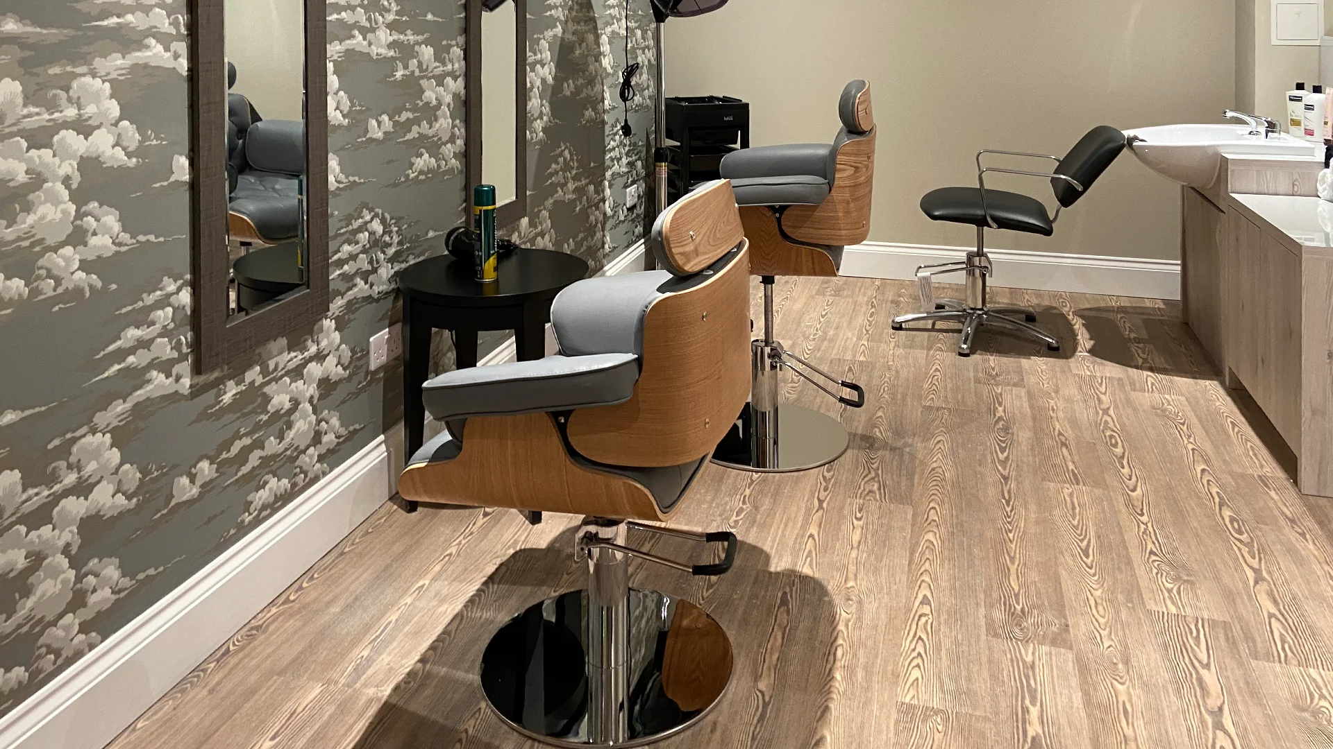 A hair salon area with styling chairs and mirrors