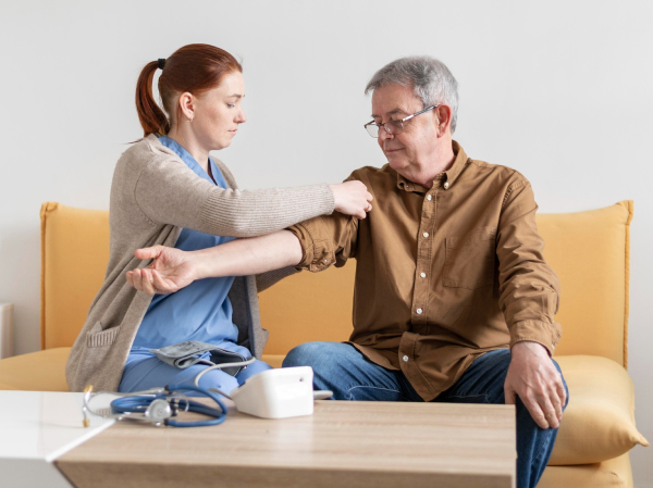 Nurse assisting an elderly man with a medical check-up.