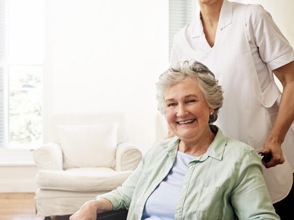 Smiling resident with caregiver in cozy interior