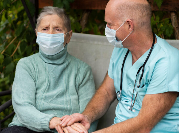 Caregiver interacting with elderly resident outdoors