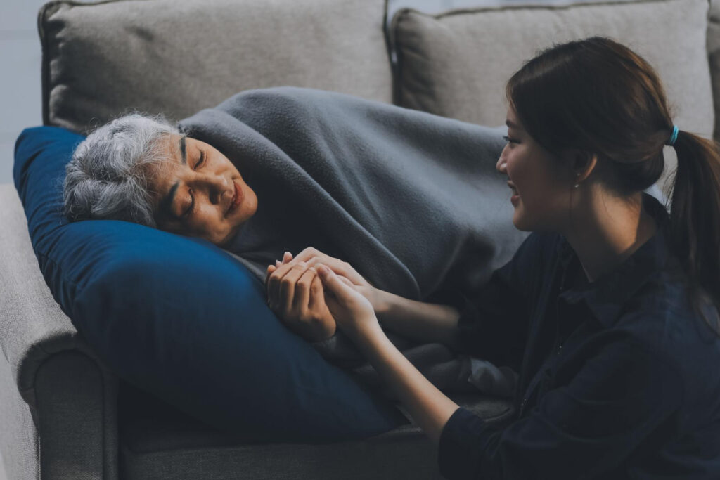A caregiver holding hands with an elderly resident.