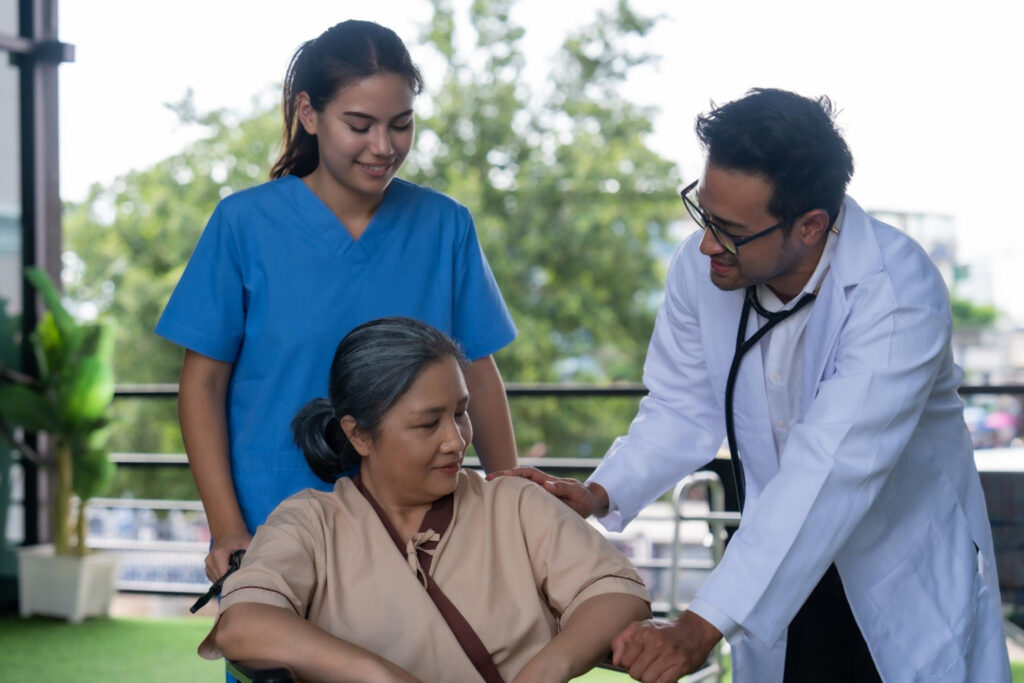 Healthcare staff interacting with a resident outdoors.