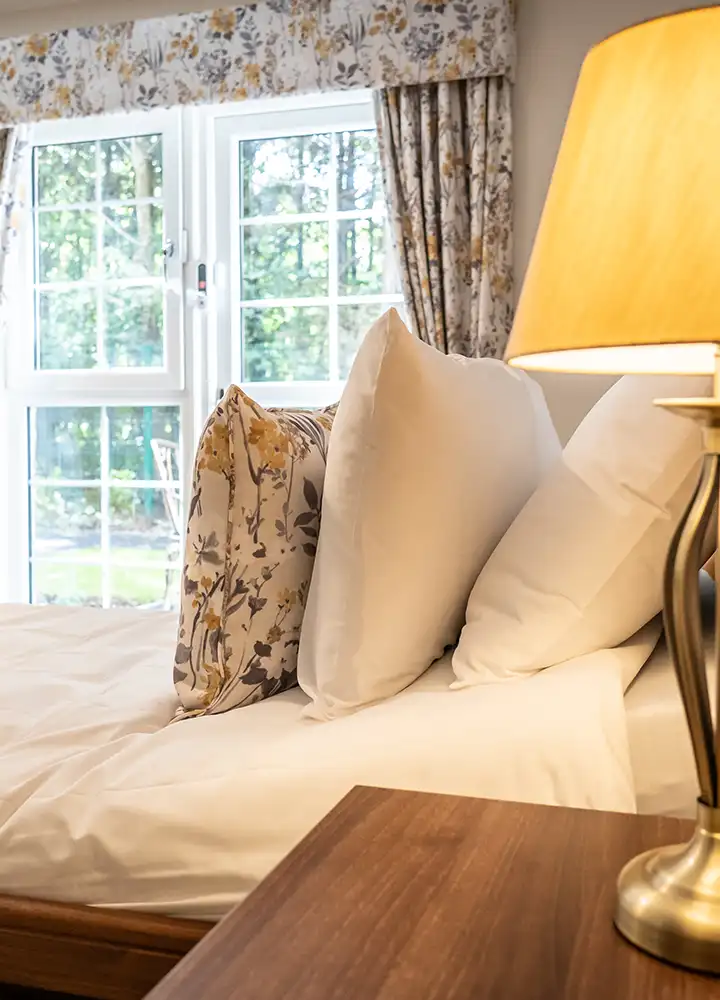 Cozy bedroom with decorative pillows and lamp