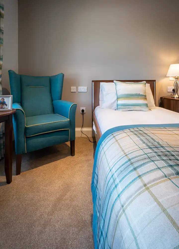 Cozy resident room with a bed and armchair