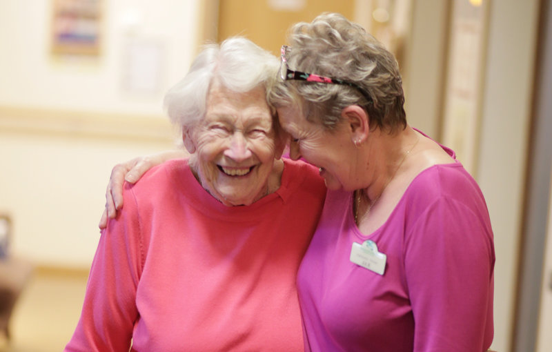 Staff member and resident smiling together