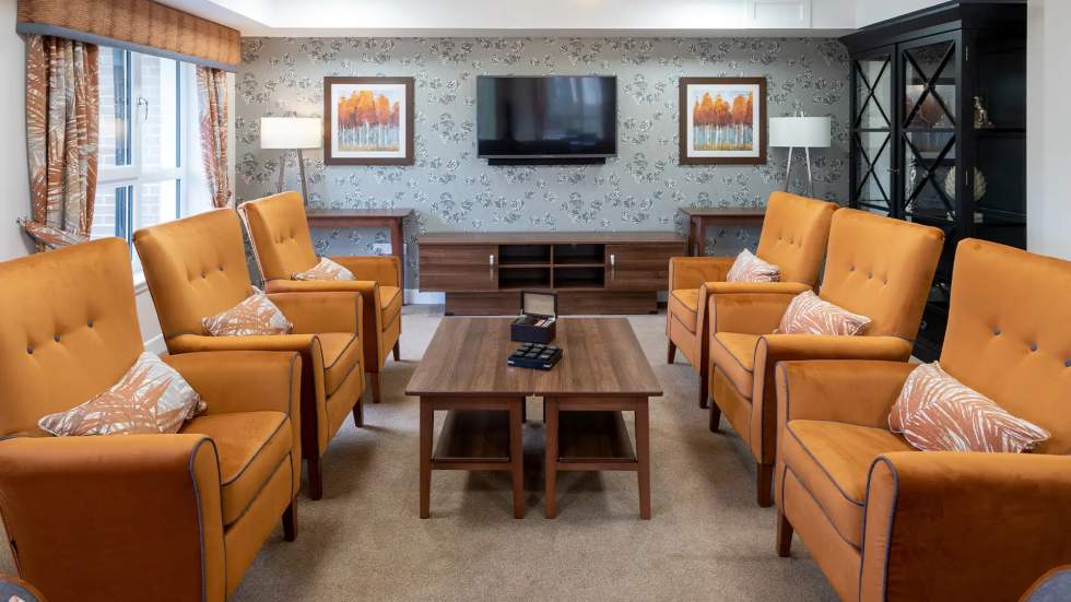 Common social area with orange chairs and art