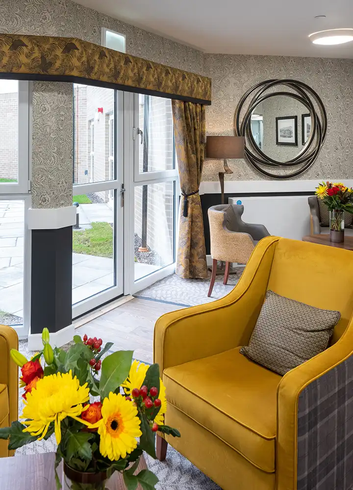 Cozy common area with floral arrangements and seating.