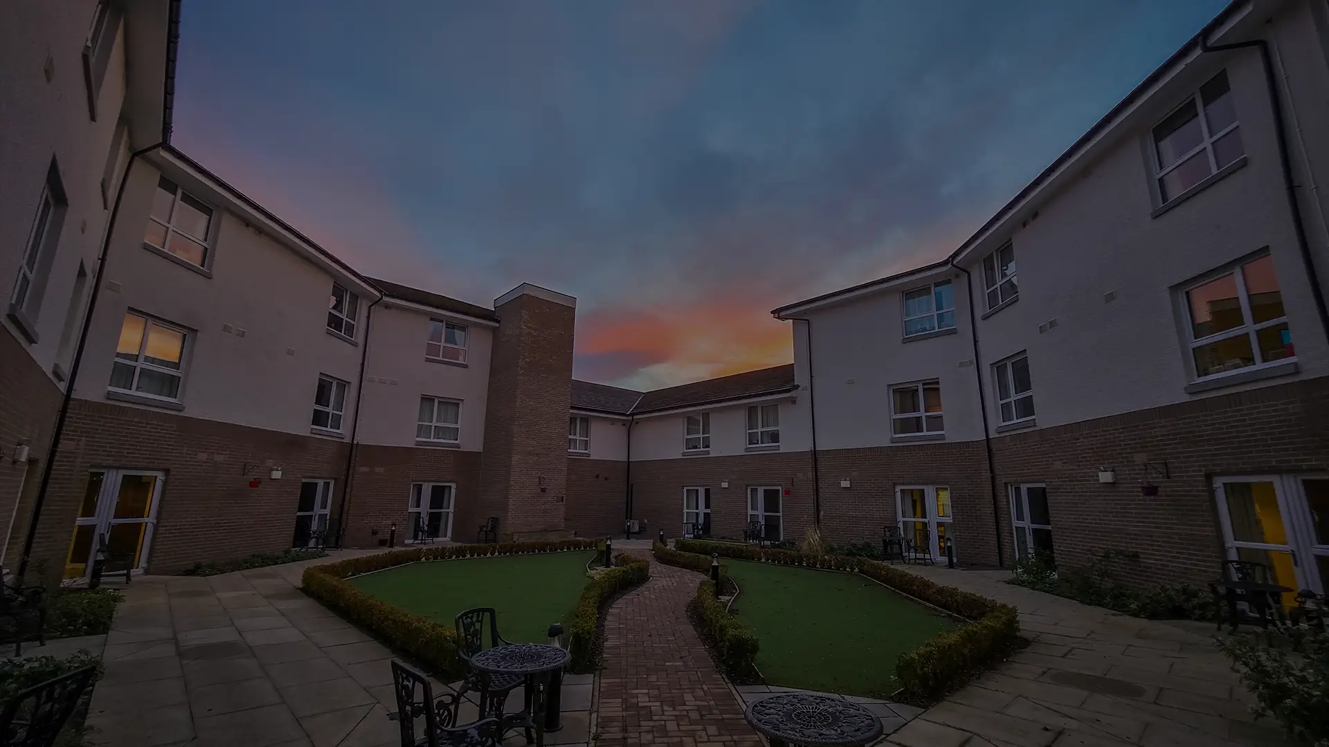 Courtyard area of a senior living facility at sunset.