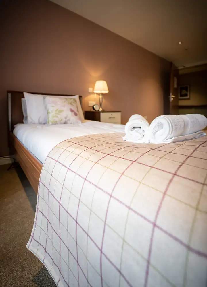 Cozy resident room with bed and towels