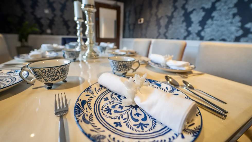 A beautifully set dining table with floral plates.