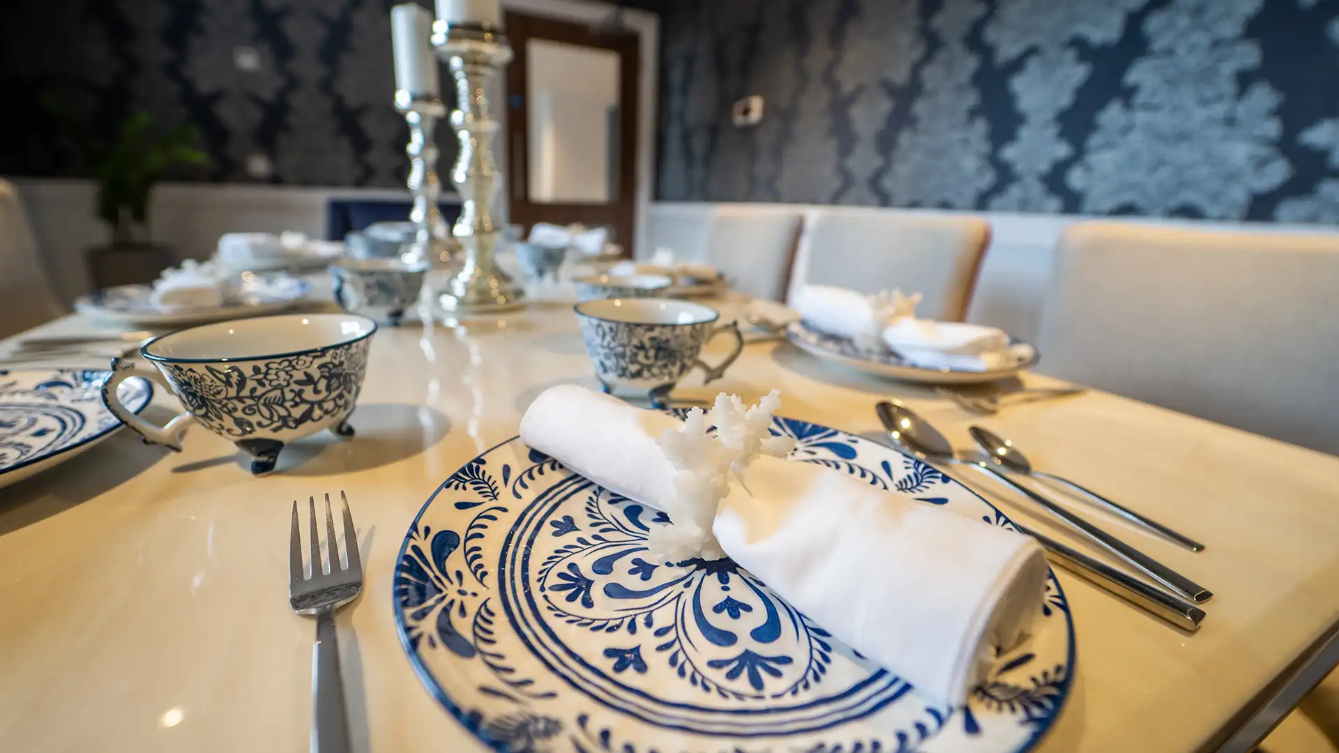 Elegantly set dining table with blue and white tableware.