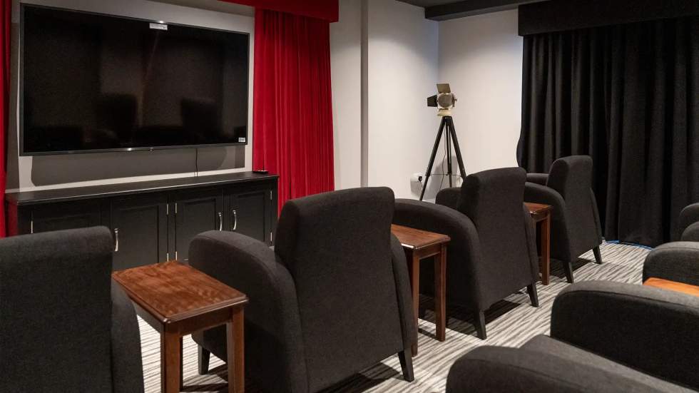 Common area with theater seating and television.
