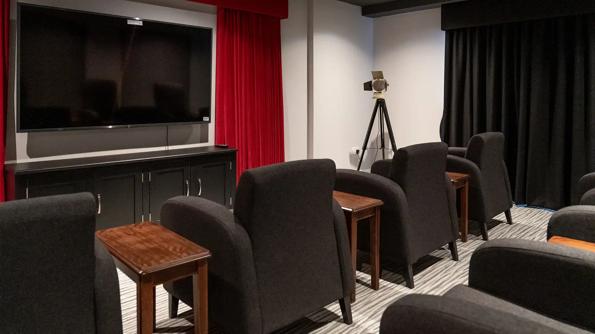 A cozy common area with seating and a TV.
