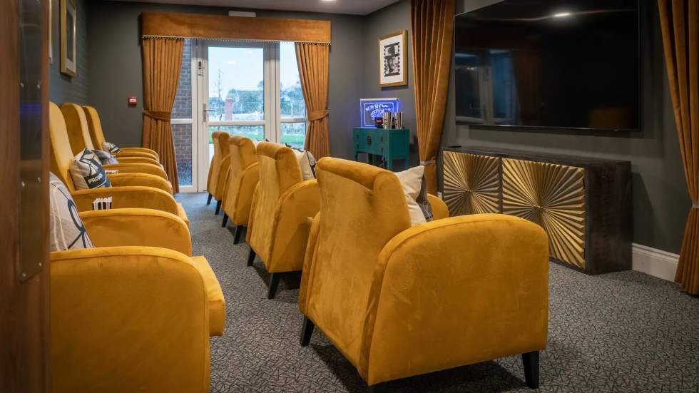 Cozy common area with yellow chairs and a TV