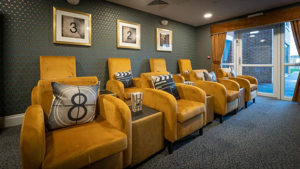Seating area with yellow chairs and decorative wall.