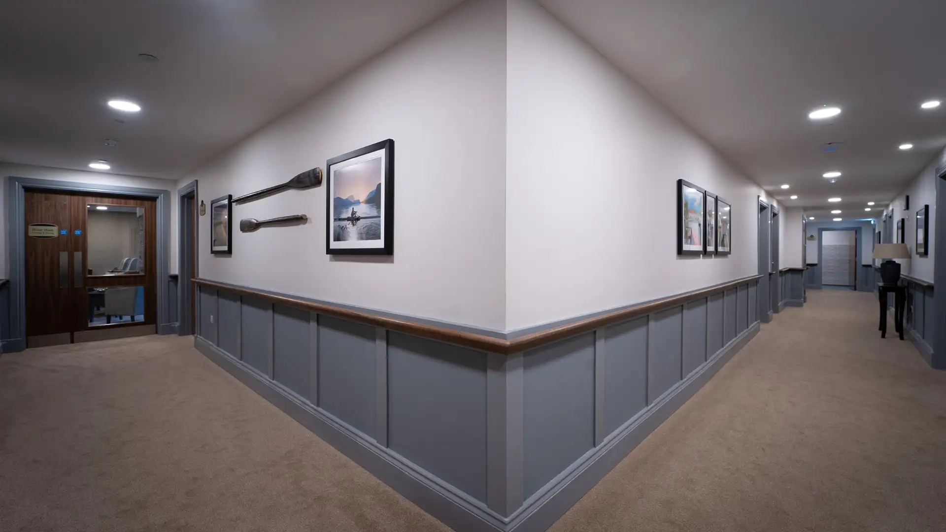 Interior hallway with framed artwork and soft lighting.
