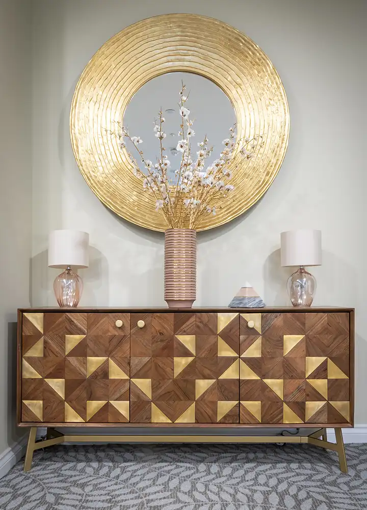 Decorative interior space with a patterned console and mirror.