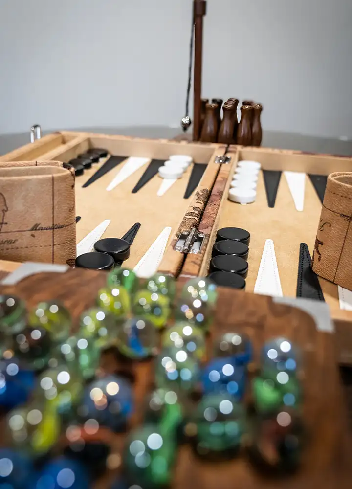 Close-up of a backgammon and marble game setup.