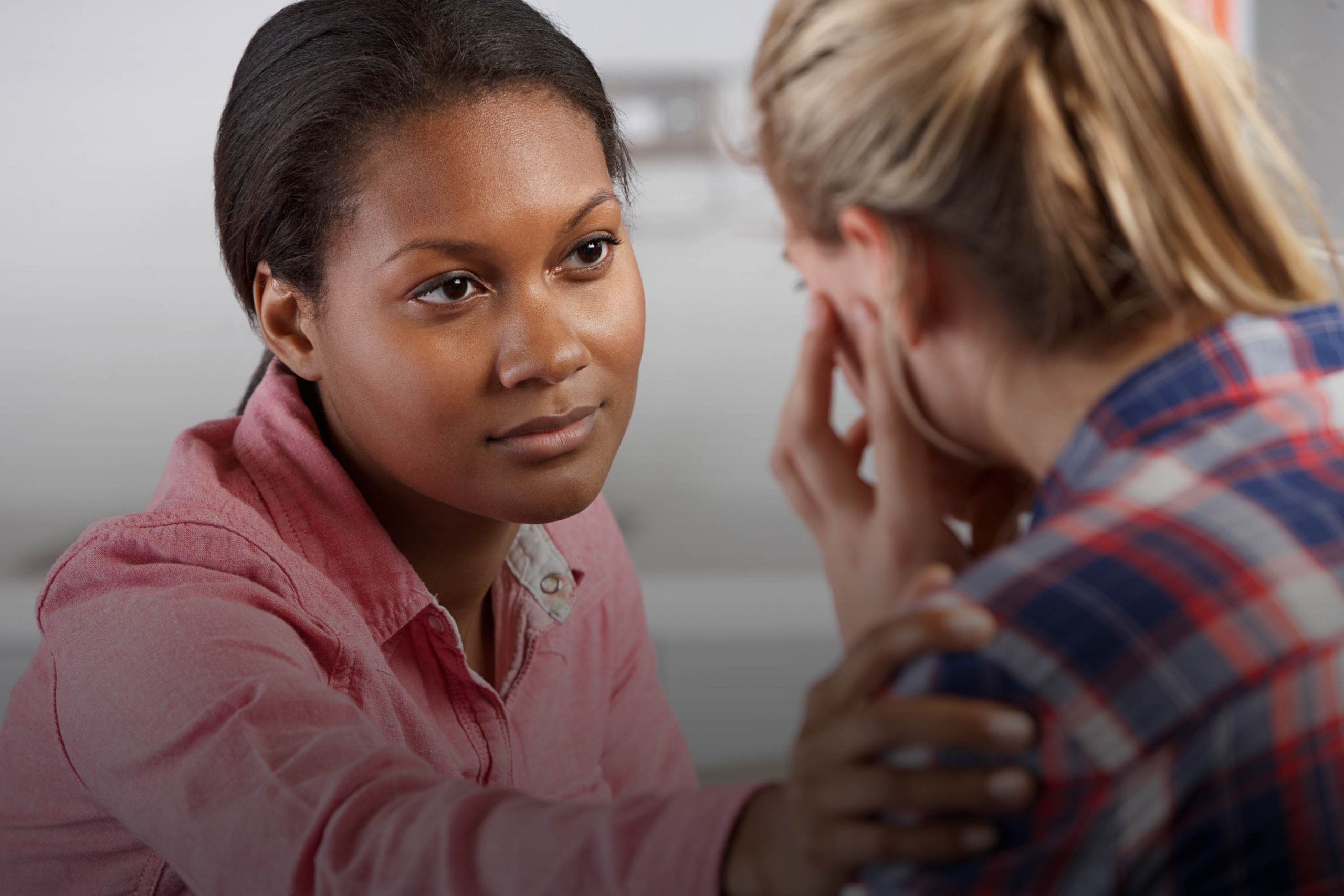 Caregiver comforting a resident in an interior setting.
