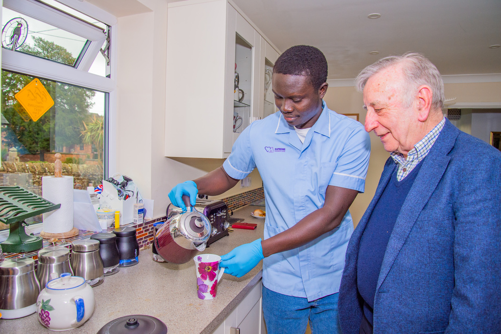 Caregiver serving tea to a senior resident.