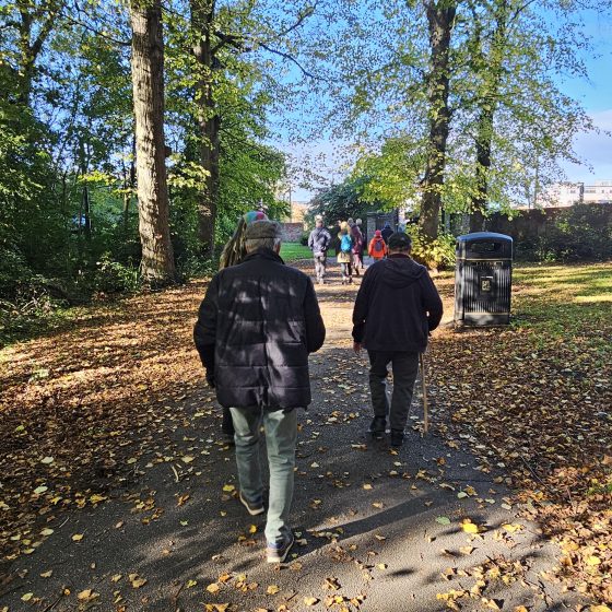 Residents enjoying a walk in a leafy outdoor area.