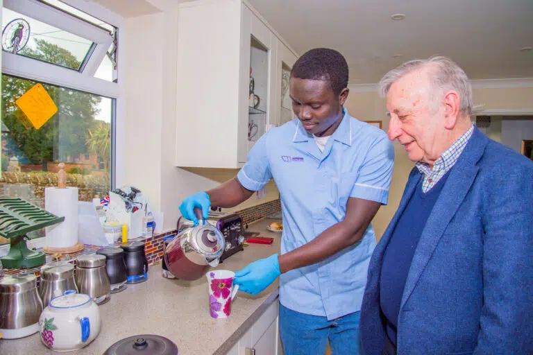 Staff member serving tea to a senior resident
