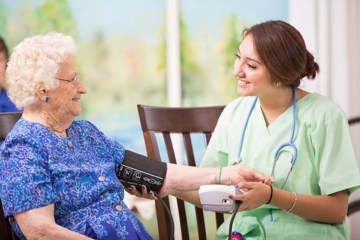 Nurse taking blood pressure of elderly resident