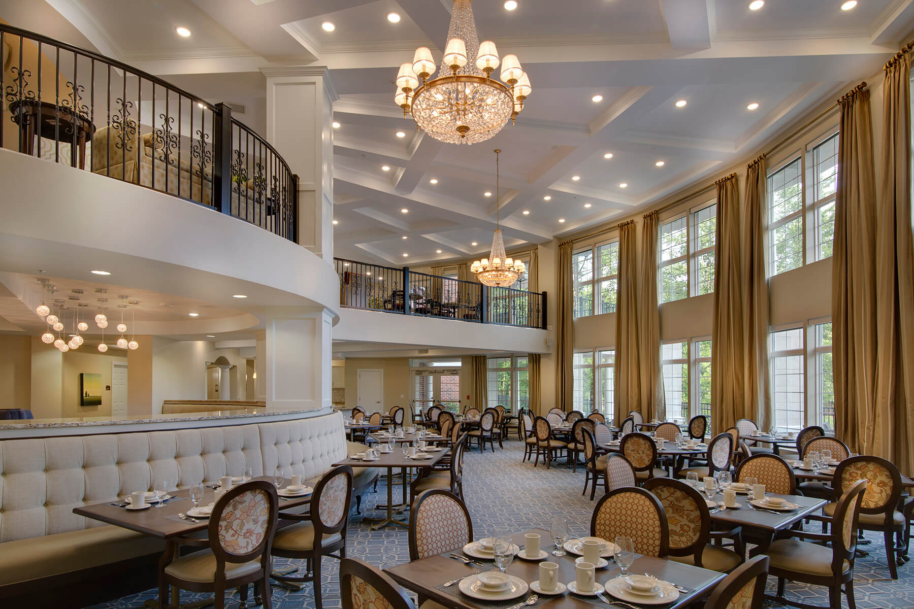 Elegant dining room with chandeliers and tables set for meals.