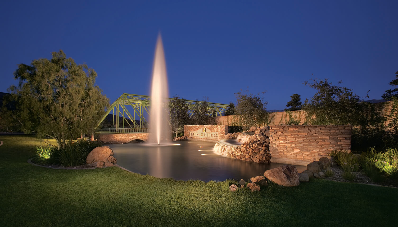Landscaped pond with a fountain in the evening