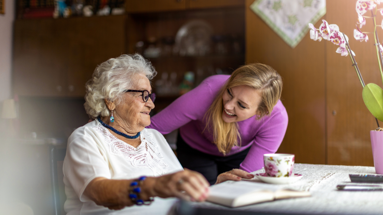 Senior woman talking with caregiver at a table