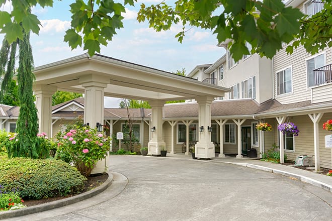 Entrance of a senior living facility with outdoor flowers