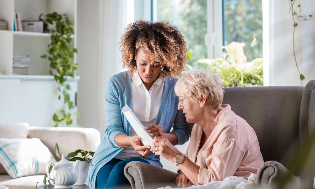 Caregiver assisting an elderly woman in a comfortable setting