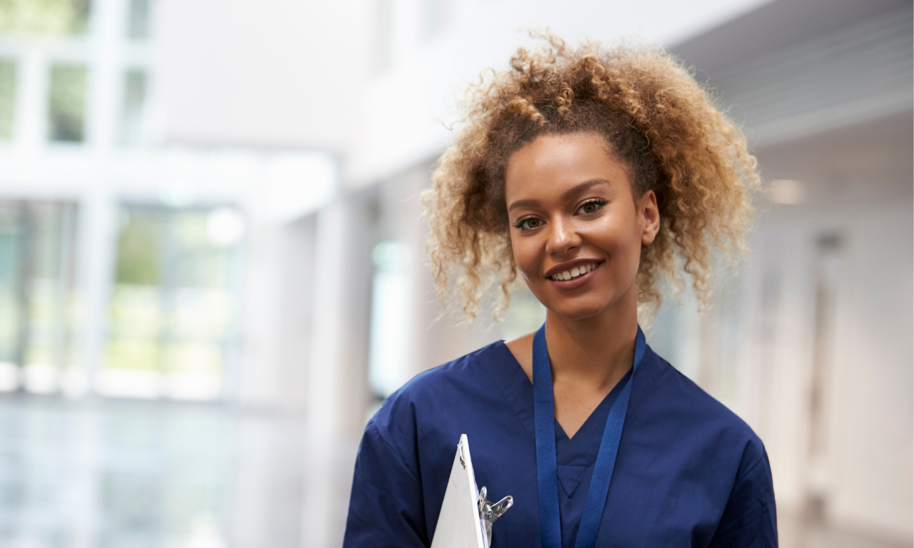 Healthcare worker smiling in a hallway