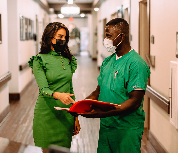 Staff member engages with a visitor in a hallway