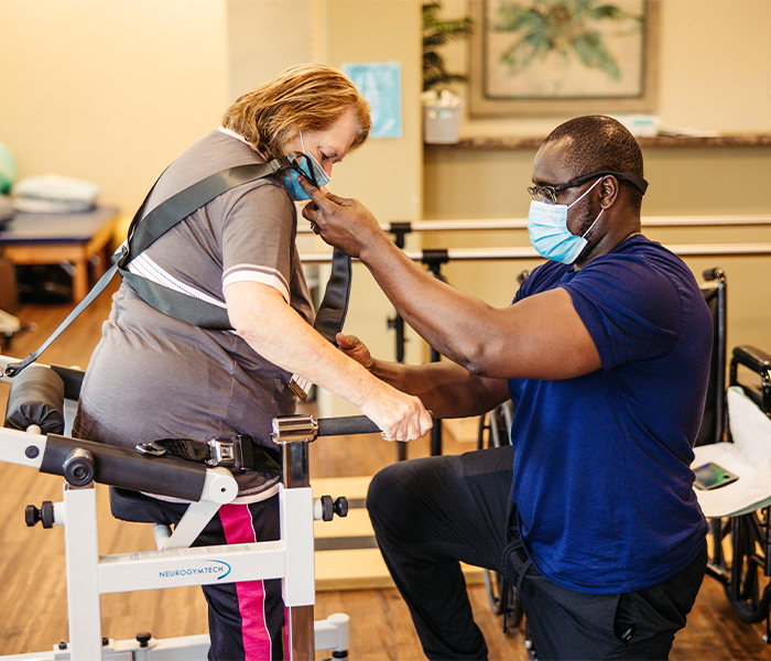 Staff assisting resident with therapy equipment