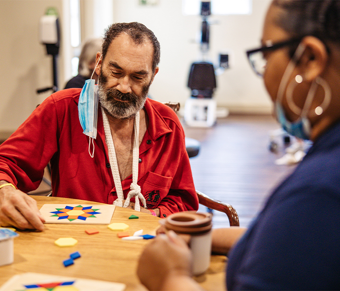 Resident and staff member engaging in an activity.