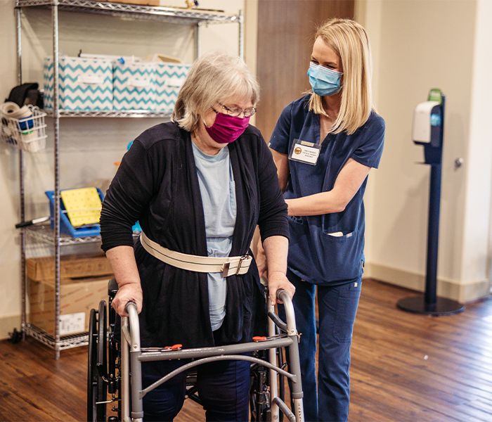 Staff assisting a resident in a common area.